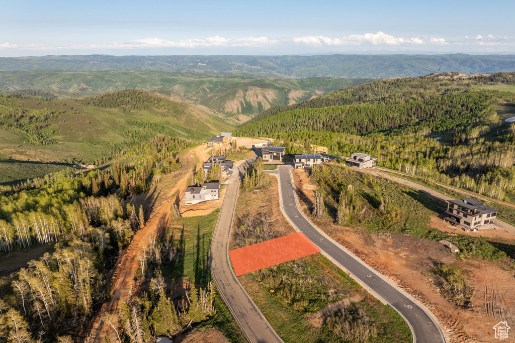 Aerial view of property and surrounding area with a mountain backdrop