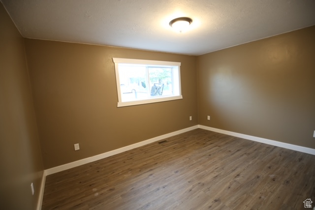 Unfurnished room featuring dark wood-style floors