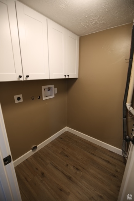 Washroom with hookup for an electric dryer, dark wood-style floors, a textured ceiling, cabinet space, and washer hookup