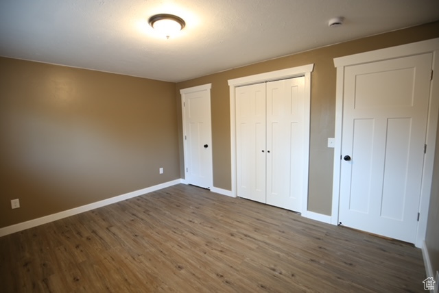 Unfurnished bedroom with dark wood-type flooring and a closet