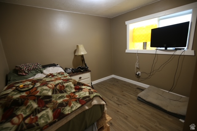 Bedroom featuring dark wood-style flooring and baseboards