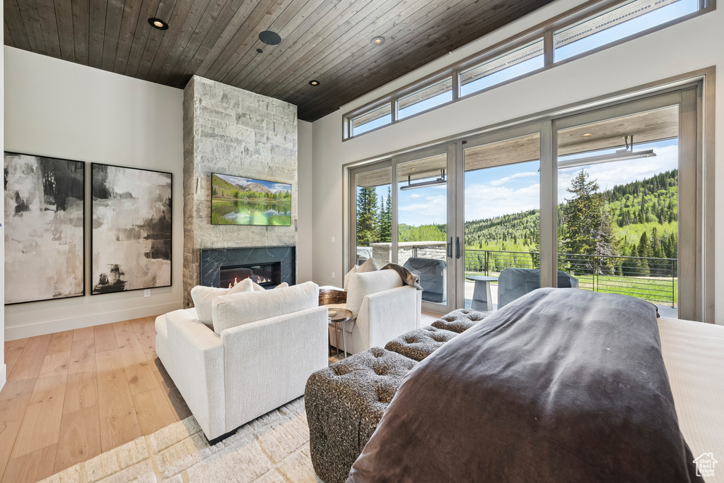 Bedroom featuring access to outside, a fireplace, wood ceiling, recessed lighting, and light wood-type flooring