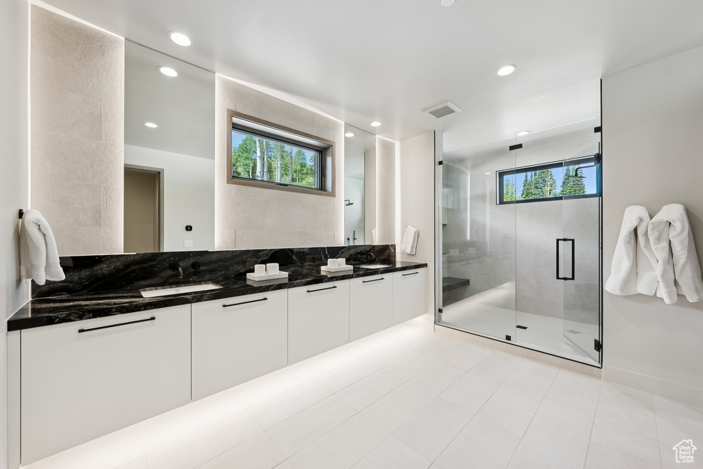 Full bath featuring double vanity, a shower stall, and recessed lighting