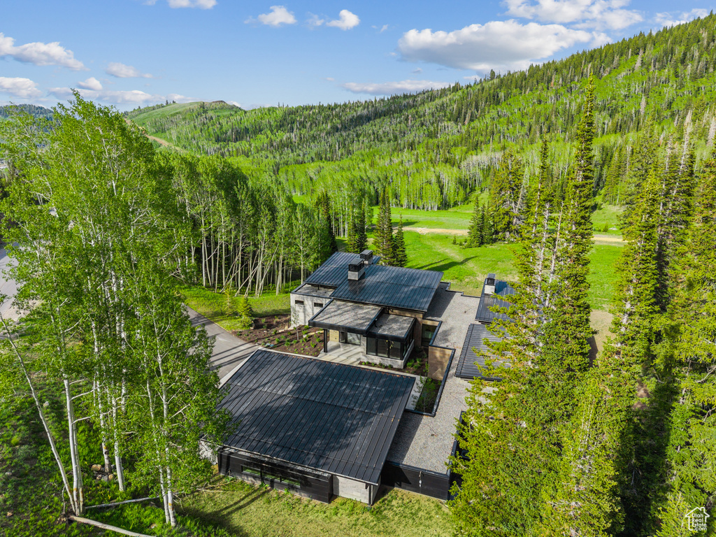 View of subject property featuring a forest and a mountain backdrop