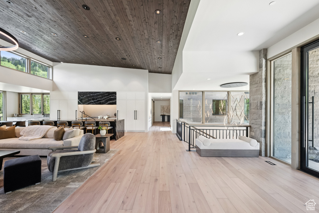 Living room with a high ceiling, hardwood / wood-style flooring, and recessed lighting