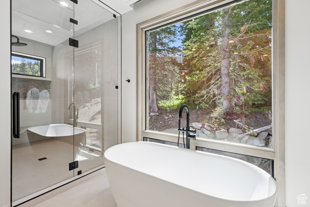 Bathroom featuring a shower stall, tile patterned flooring, and plenty of natural light
