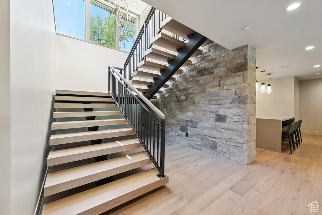 Stairs with wood-type flooring and recessed lighting