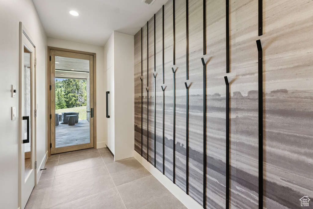 Doorway with light tile patterned floors and recessed lighting