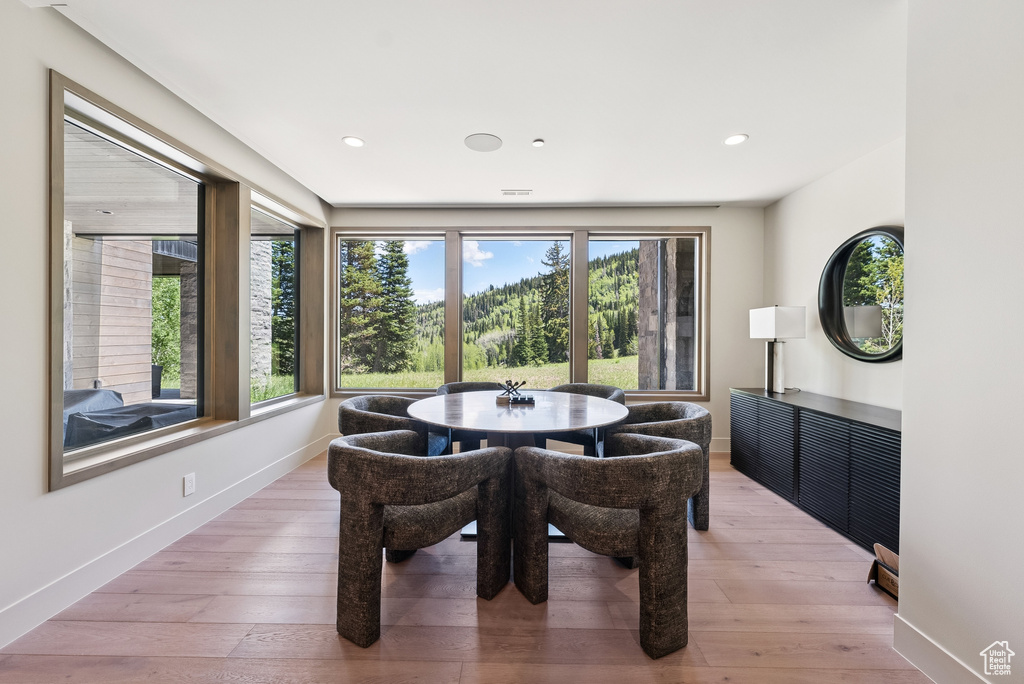 Dining room with light wood-type flooring and recessed lighting