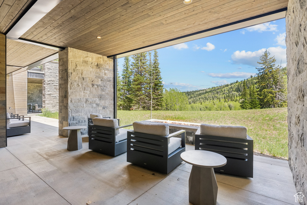 View of patio with a wooded view and an outdoor living space