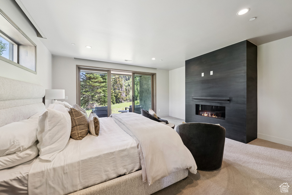 Bedroom with access to outside, carpet floors, a large fireplace, and recessed lighting