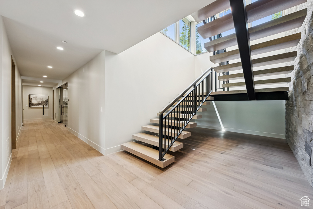 Stairway with recessed lighting and wood finished floors