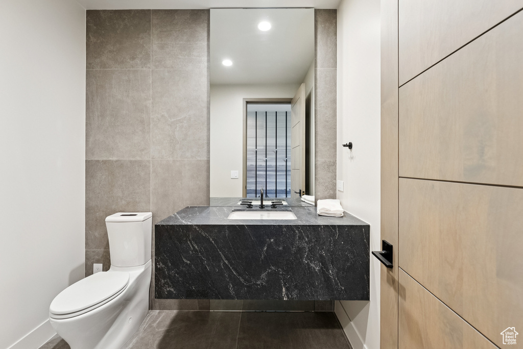 Bathroom with vanity, tile walls, and recessed lighting