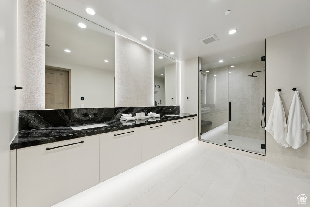 Full bathroom with double vanity, recessed lighting, a shower stall, and tile patterned floors