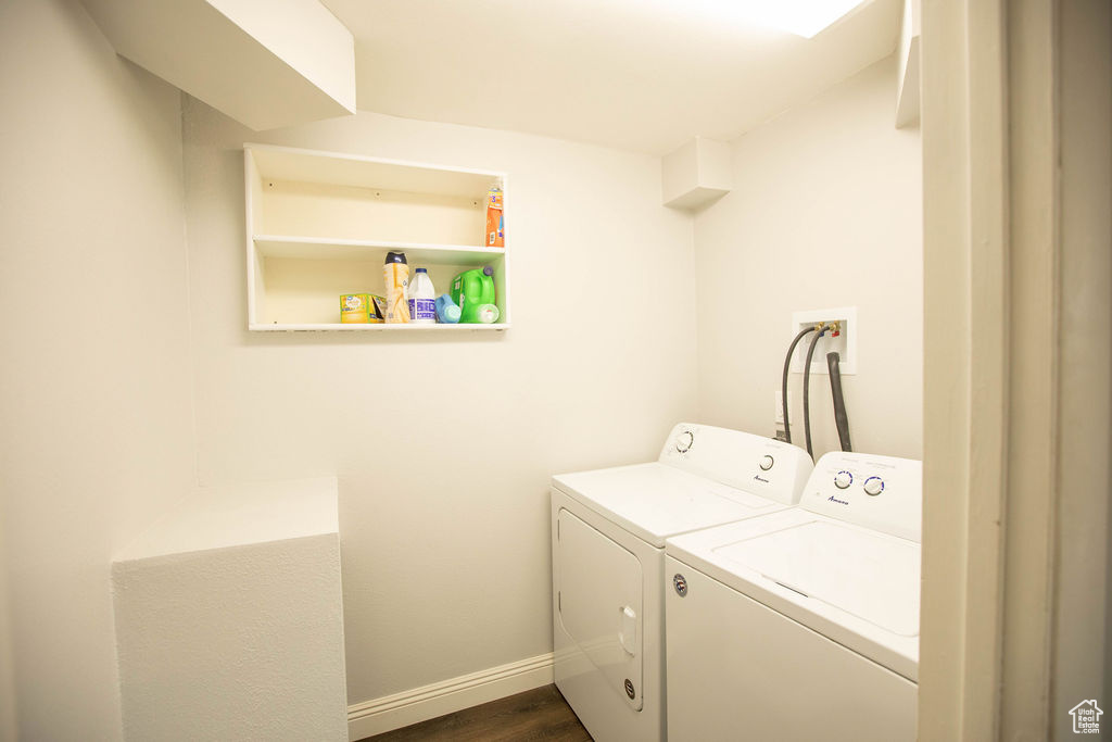 Laundry area with washing machine and clothes dryer and dark wood-type flooring