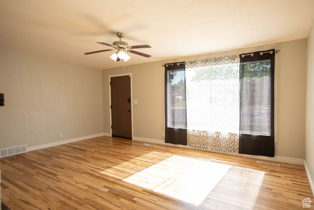 Unfurnished room with wood finished floors and ceiling fan