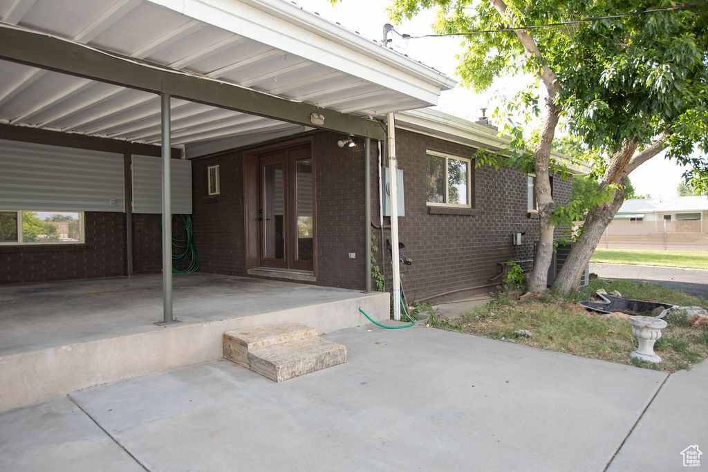 Property entrance featuring brick siding and french doors