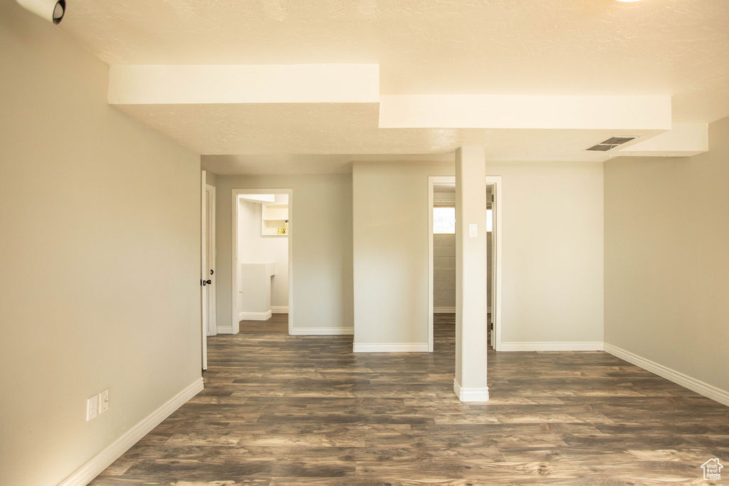 Below grade area with baseboards and dark wood-style floors