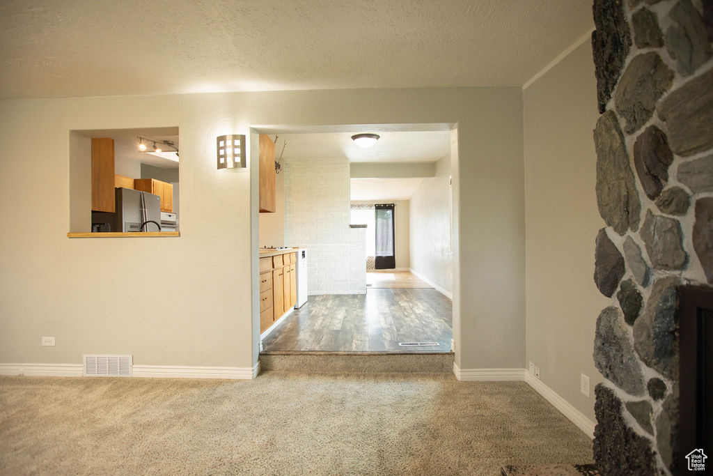 Hallway featuring carpet floors and a textured ceiling