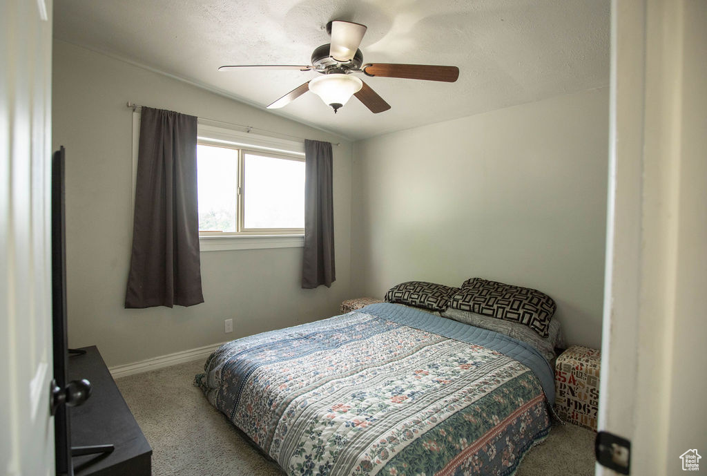 Bedroom featuring carpet, lofted ceiling, and ceiling fan