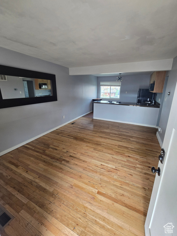 Empty room featuring hardwood / wood-style floors and a chandelier