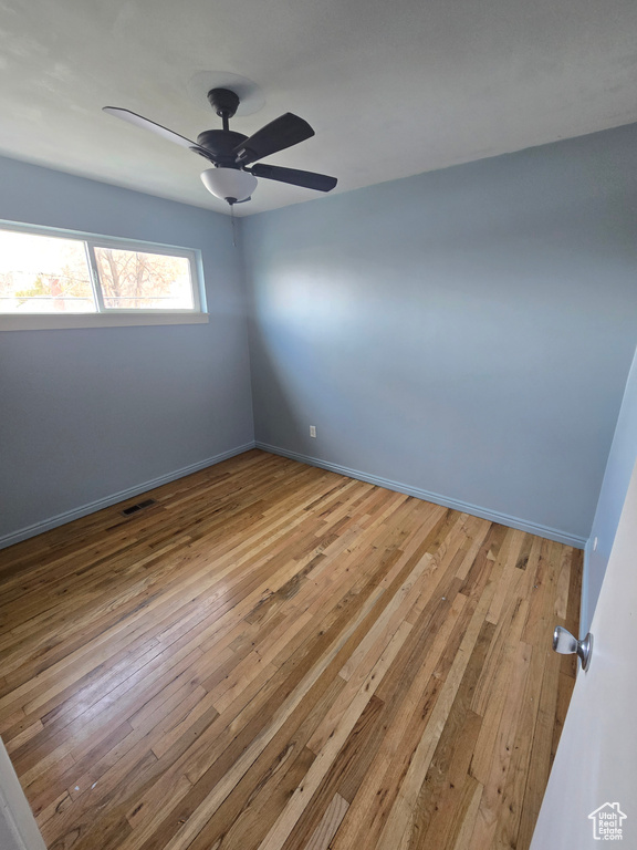 Spare room with light wood-style floors and a ceiling fan
