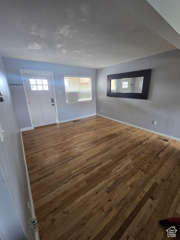 Foyer with dark wood finished floors and baseboards