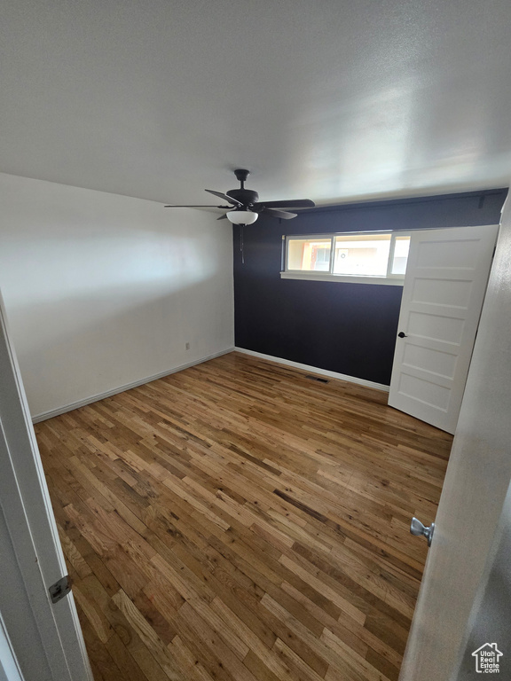 Spare room with wood-type flooring and a ceiling fan