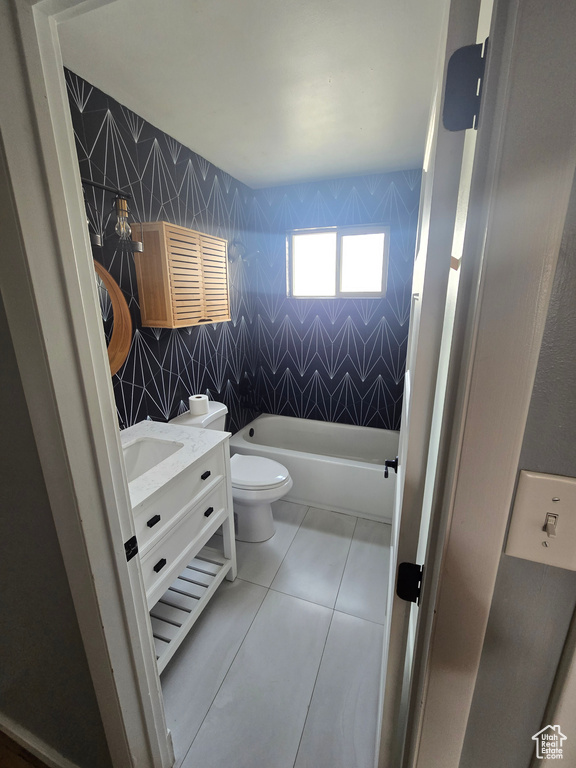 Full bath featuring a bathtub, vanity, tile patterned floors, and tile walls
