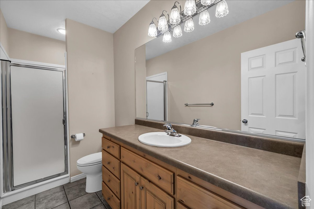 Bathroom featuring a stall shower, tile patterned flooring, and vanity