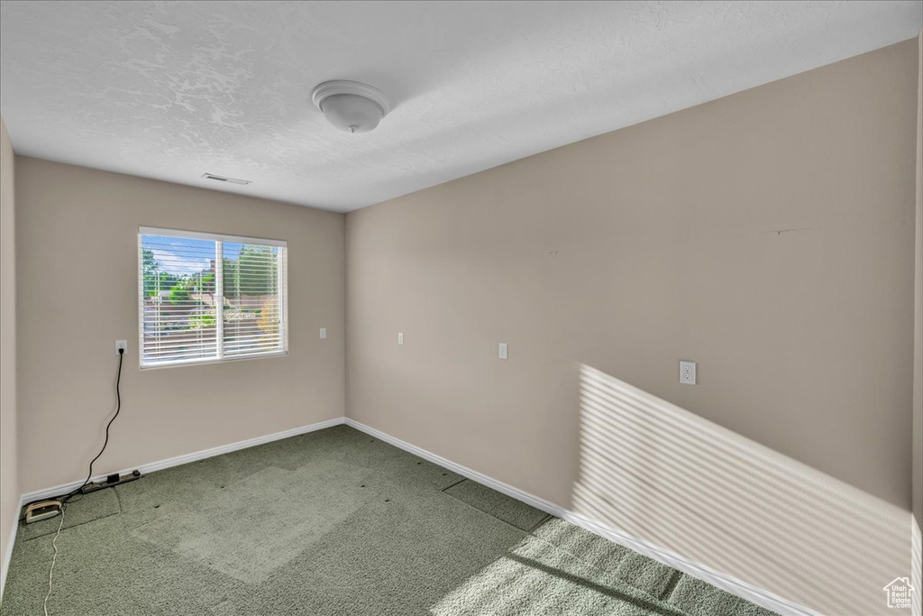 Carpeted spare room with baseboards