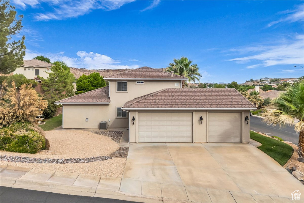 View of front facade featuring stucco siding, an attached garage, concrete driveway, and a tiled roof