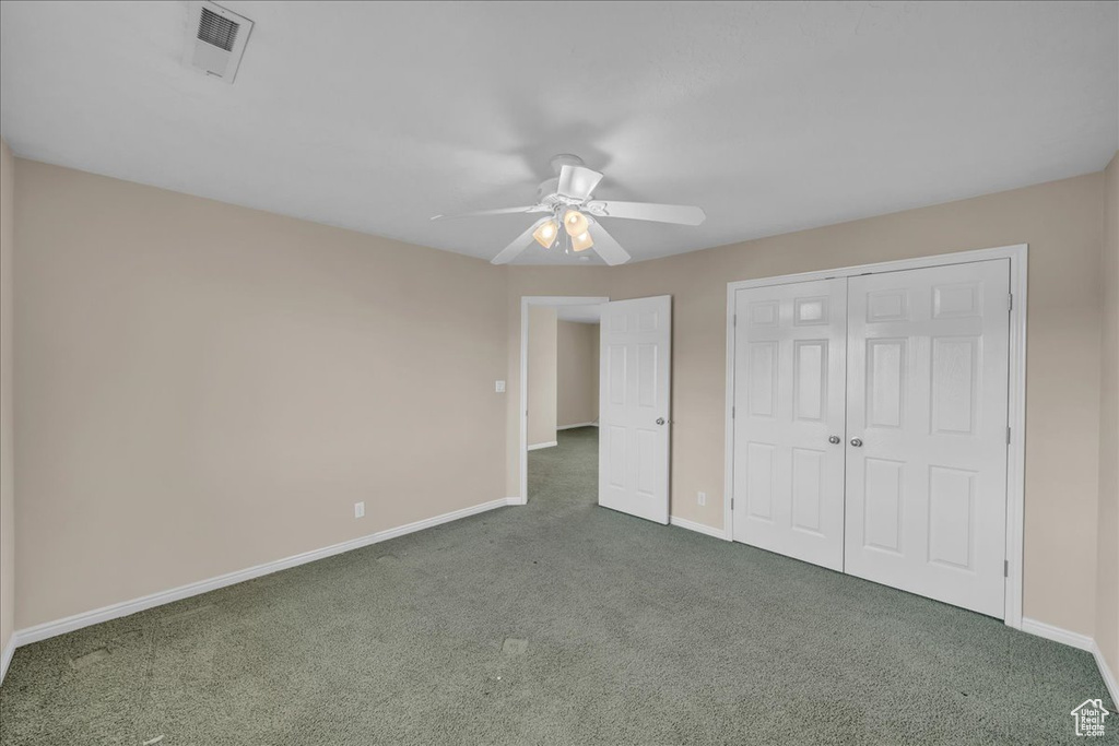 Unfurnished bedroom featuring carpet, a closet, and a ceiling fan