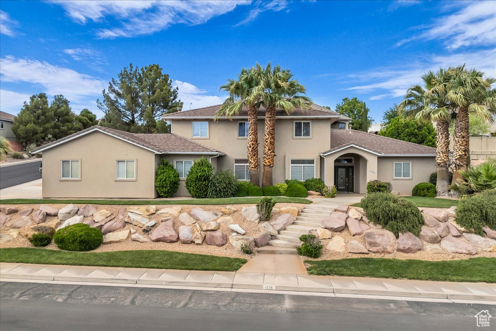 View of front of house featuring stucco siding and a tiled roof