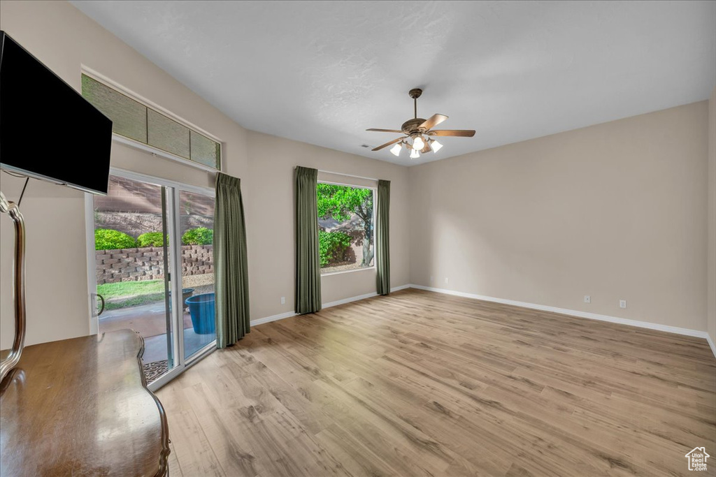 Empty room with ceiling fan and light wood-style floors