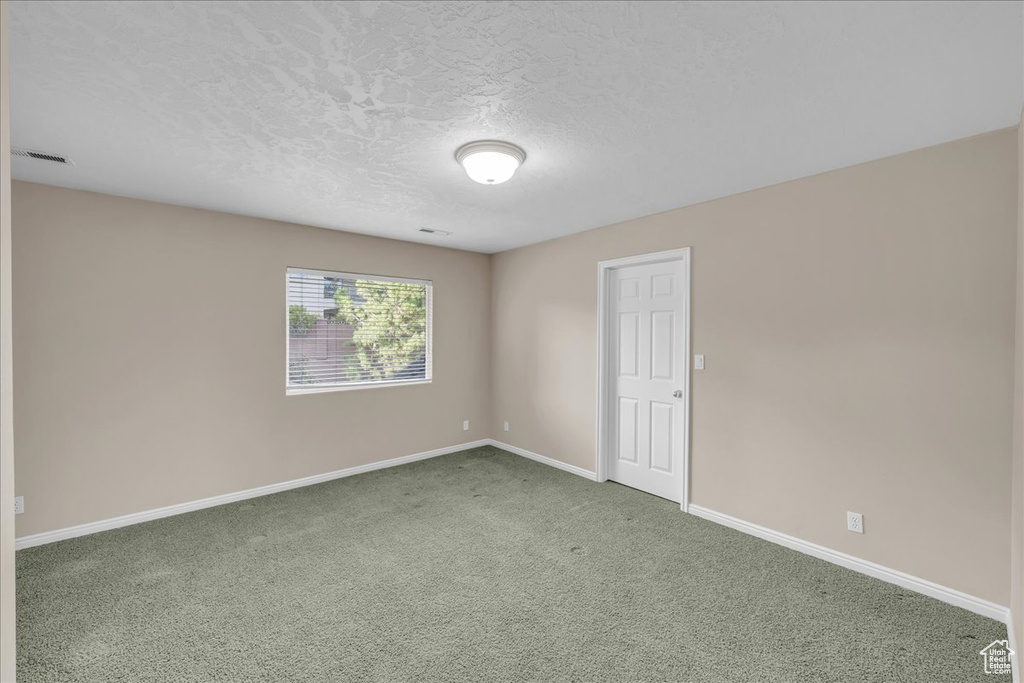 Spare room with carpet and a textured ceiling