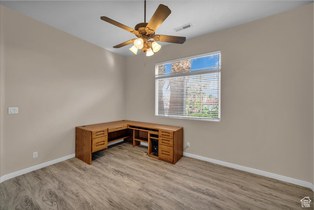 Unfurnished office featuring light wood-style flooring and a ceiling fan