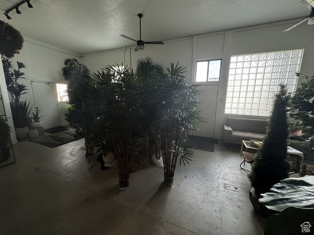 Misc room featuring ceiling fan, a textured ceiling, and unfinished concrete floors