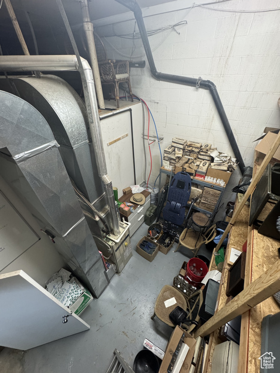 Unfinished basement featuring concrete block wall