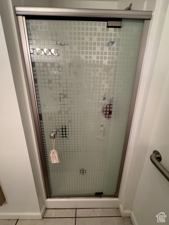 Full bath with a stall shower and tile patterned flooring