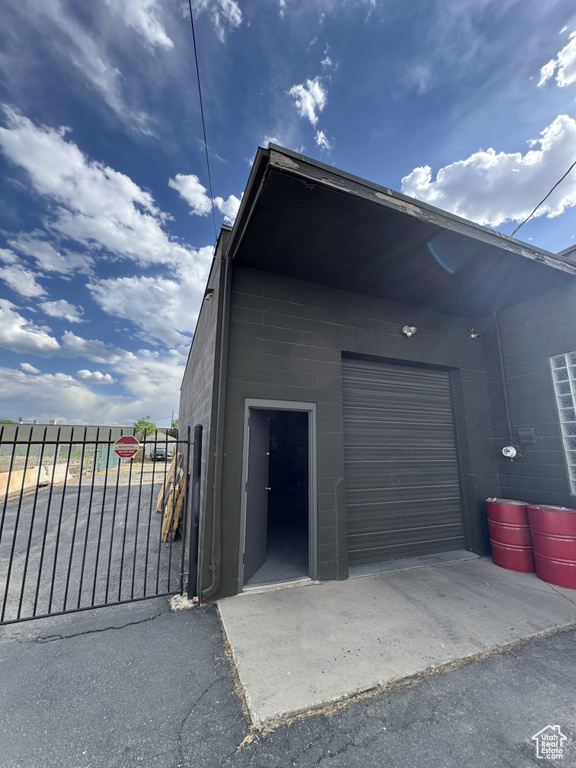 Garage featuring asphalt driveway and a gate