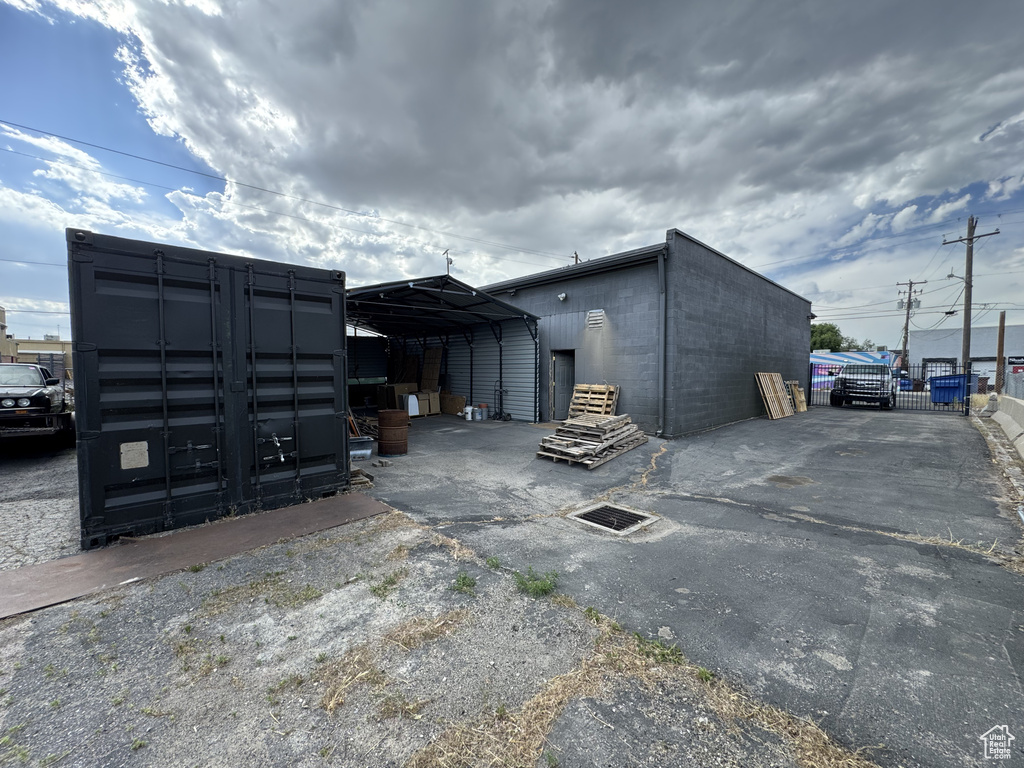 View of outdoor structure featuring a carport and asphalt driveway