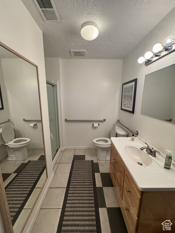 Bathroom featuring vanity, a shower stall, and a textured ceiling