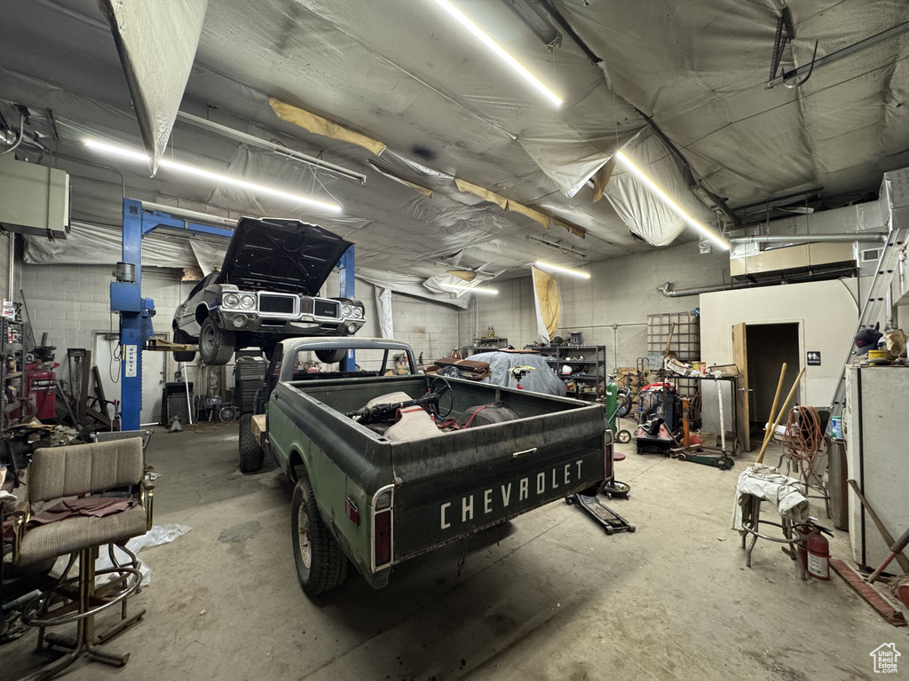 Garage featuring a workshop area and concrete block wall