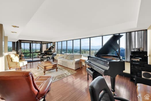 Living area with wood finished floors and floor to ceiling windows