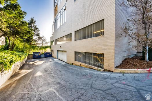 View of side of property featuring asphalt driveway and an attached garage