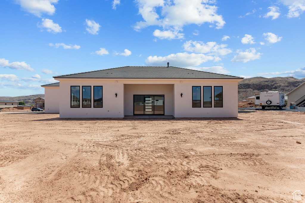 Back of property featuring a tile roof, stucco siding, and a mountain view