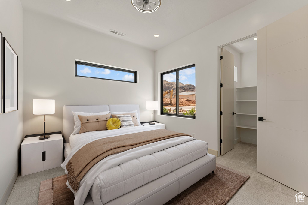 Bedroom with light colored carpet and recessed lighting