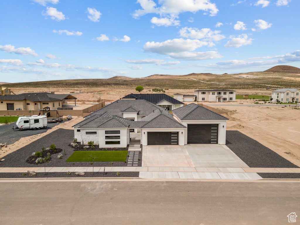 View of front of home featuring an attached garage, stucco siding, and a mountain view