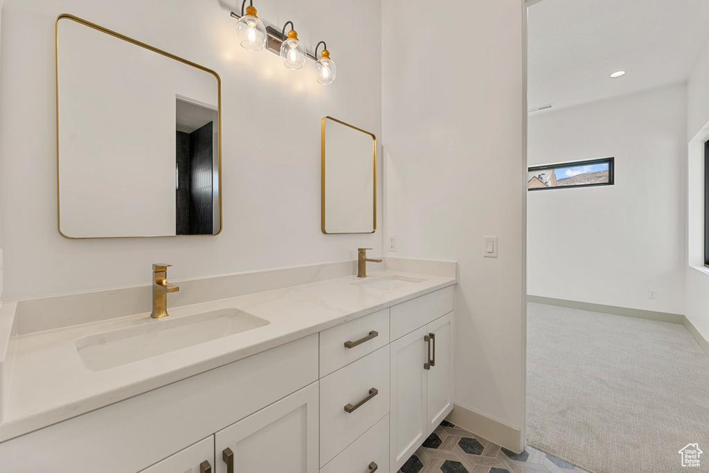 Full bath with double vanity, baseboards, and recessed lighting